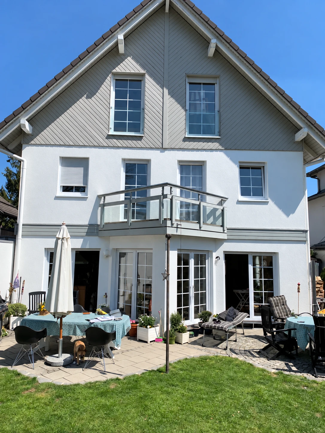 Wohnhaus mit weißer Fassade und grauem Giebel